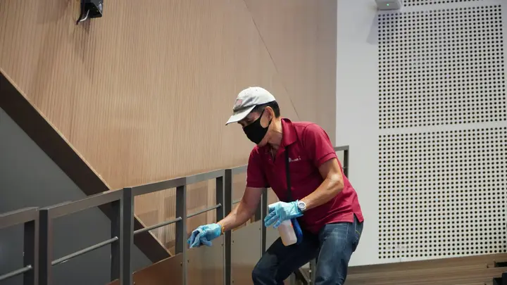 A cleaner attending carefully to the details in a commercial space